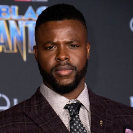 Winston Duke wears a suit for an event